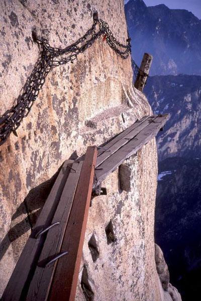 栈道上下皆是悬崖绝壁,铁索横悬,由条石搭成尺许路面,下由石柱固定,游