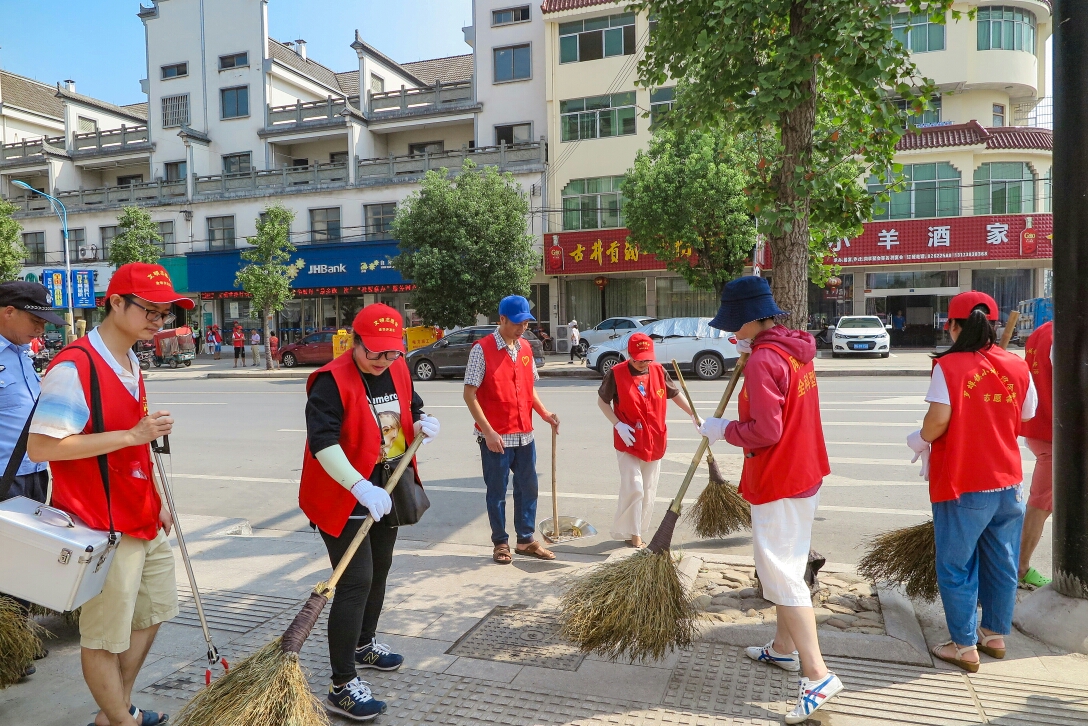 清扫垃圾 清扫着沿街店铺门口 罗埠镇党委书记吴雨澄同志说:"文明创建