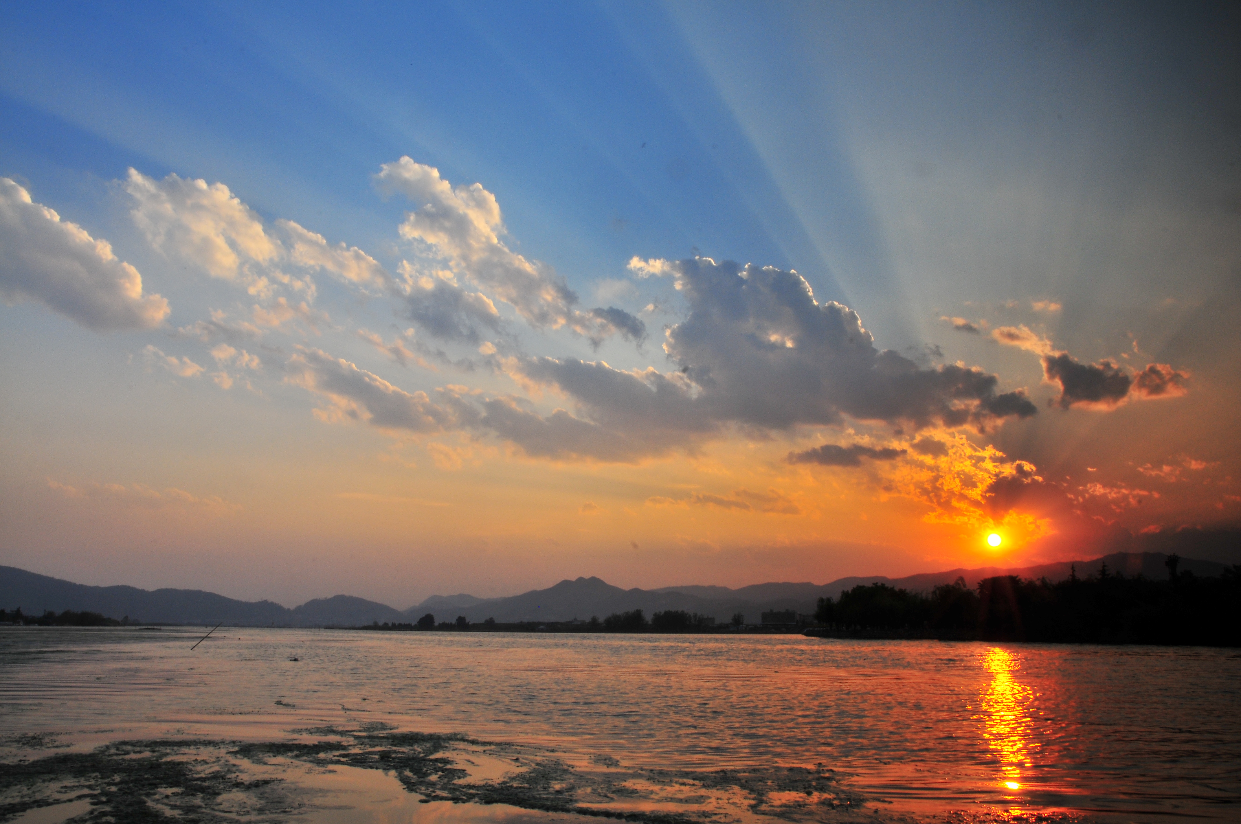 碧波荡漾的滇池,映衬着绚丽的晚霞.展现了高原湖泊多姿多彩的魅力.