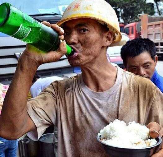 小伙子手端满满的一碗米饭,正在对瓶吹饮这啤酒,看着是不是很霸气?