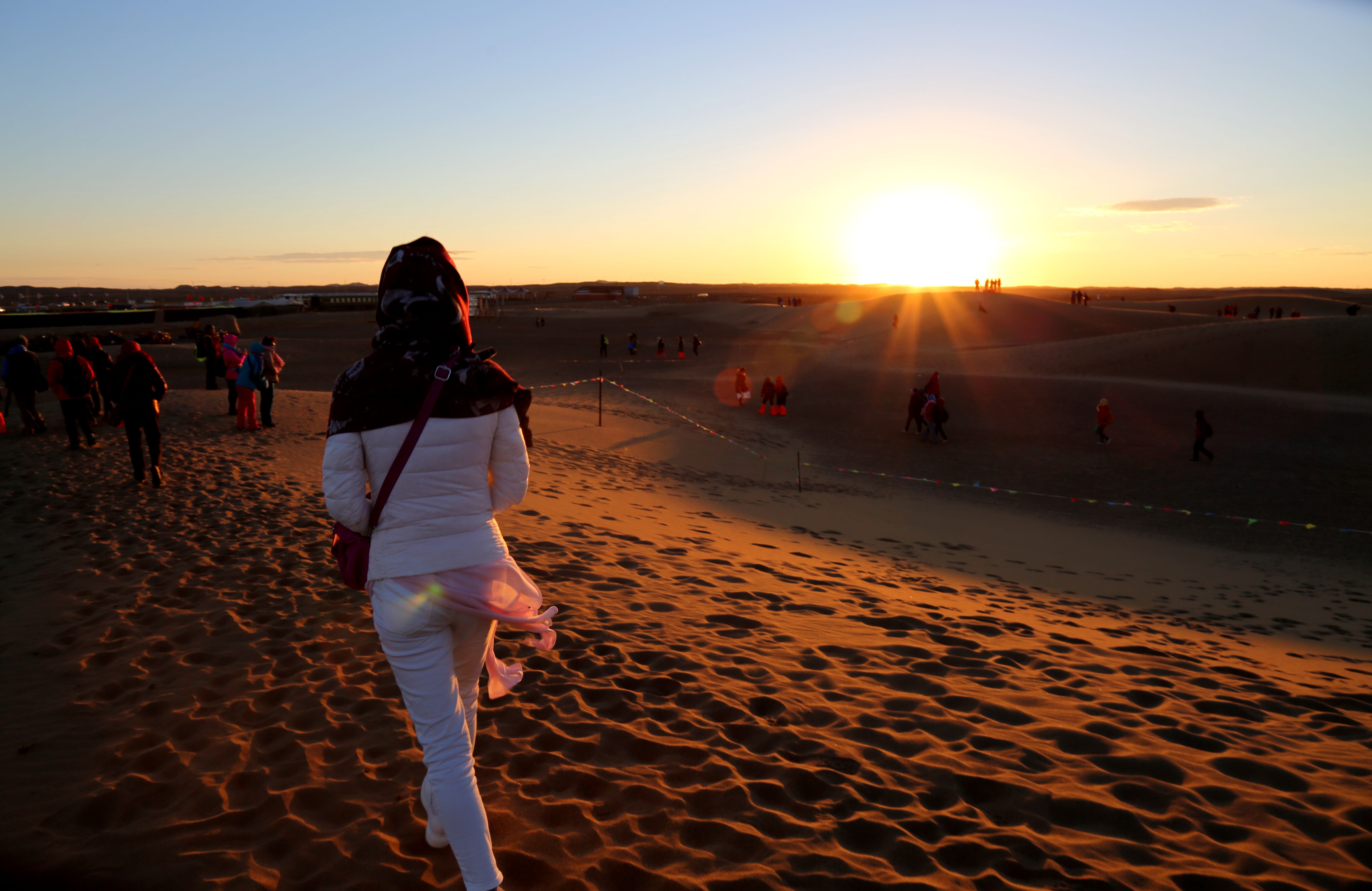 寒风细雨晓已收,八道桥上观日出.东方渐亮红日出,沙丘金黄朝霞舞.