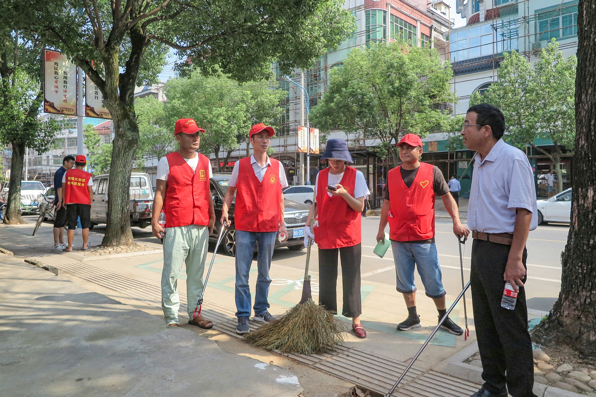 清扫垃圾 清扫着沿街店铺门口 罗埠镇党委书记吴雨澄同志说:"文明创建