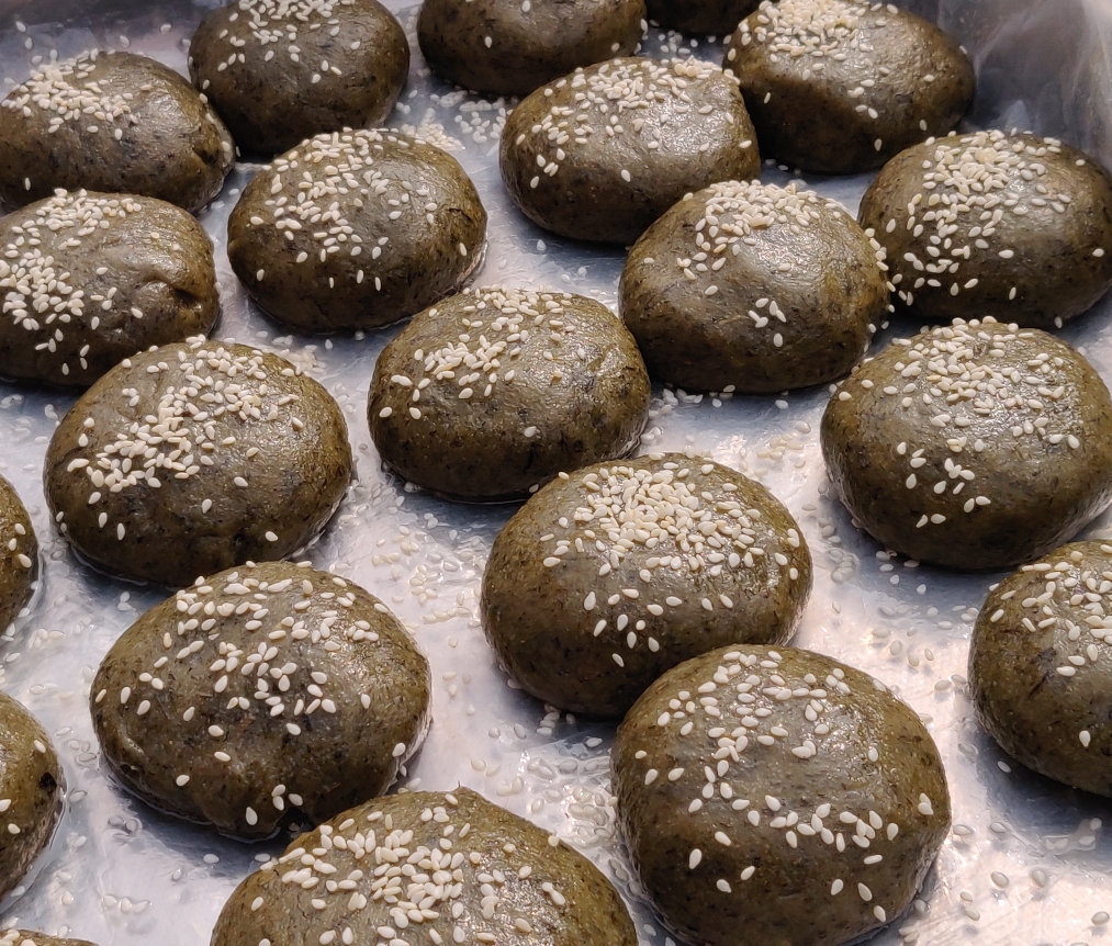 文化礼堂广场举办了一次别开生面的比赛活动:"芽麦圆子"的制作比拼赛