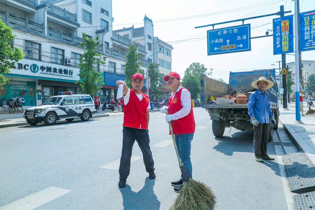 清扫垃圾 清扫着沿街店铺门口 罗埠镇党委书记吴雨澄同志说:"文明创建